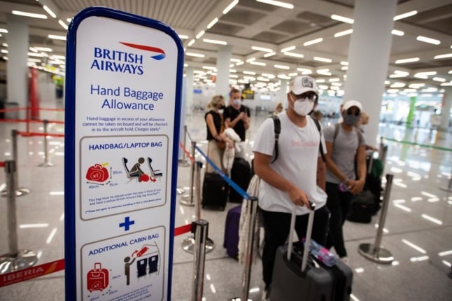 British tourists wait to check in for a flight to London at the airport in Palma de Mallorca. (Photo by JAIME REINA / AFP)