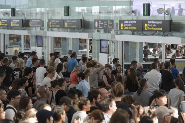 Passengers queue to pass the security control at Barcelona's El Prat airport 