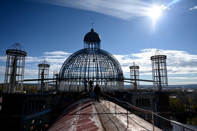 Builders work on the dome of the Cathedral of Justo on November 26th. (Photo by Gabriel BOUYS / AFP)