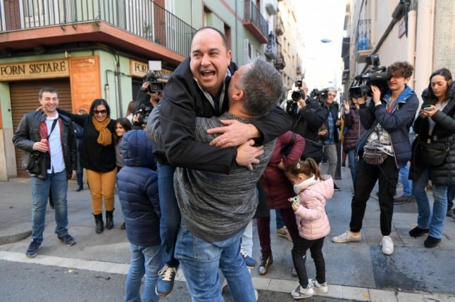 People celebrate at the Aragones Center "El Cachirulo" after winning the first prize of the draw of Spain's Christmas lottery "El Gordo" (the Fat One) in Reus on December 22, 2019. (Photo by LLUIS GENE / AFP)