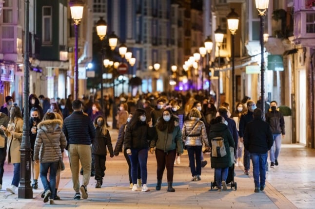 People with face masks stroll along a street in downtown Burgos. 