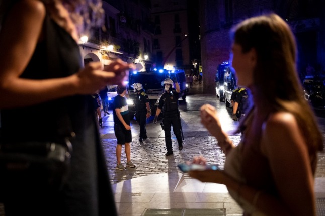 Police arrive to ask people enjoying a night out to leave as a curfew comes into effect in the Born neighbourhood of Barcelona early on July 17, 2021. 